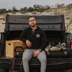 Owner of Gym Truck Chico Poses On The Tailgate of his truck with his workout equipment